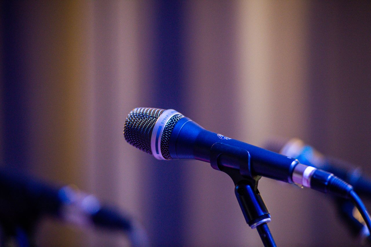 About Close-up of a professional microphone on stage with blurred bokeh background.